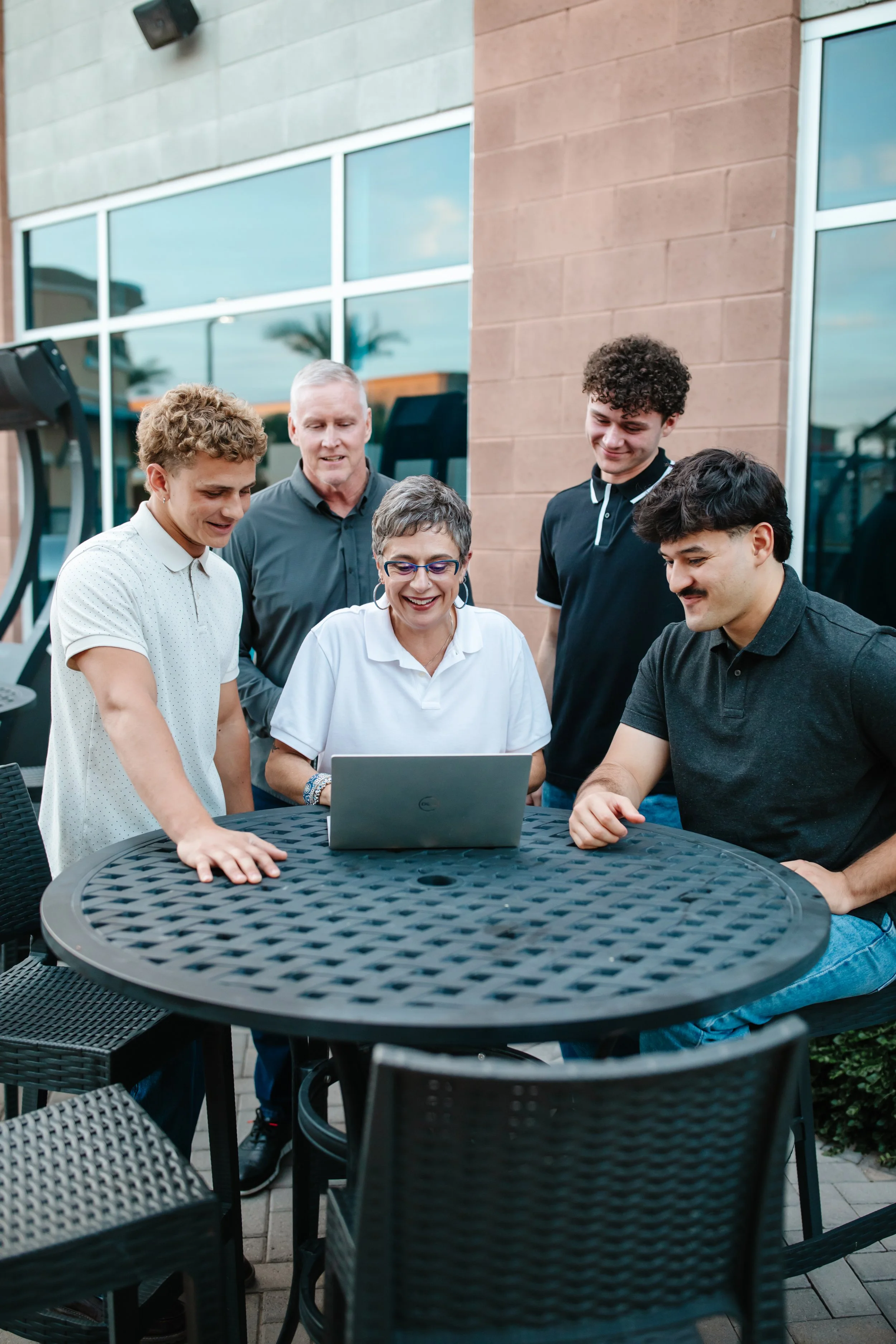 Susan Seiber, Top East Valley Realtor, and Adam Negri looking at a silver MacBook laptop together at a kitchen counter.