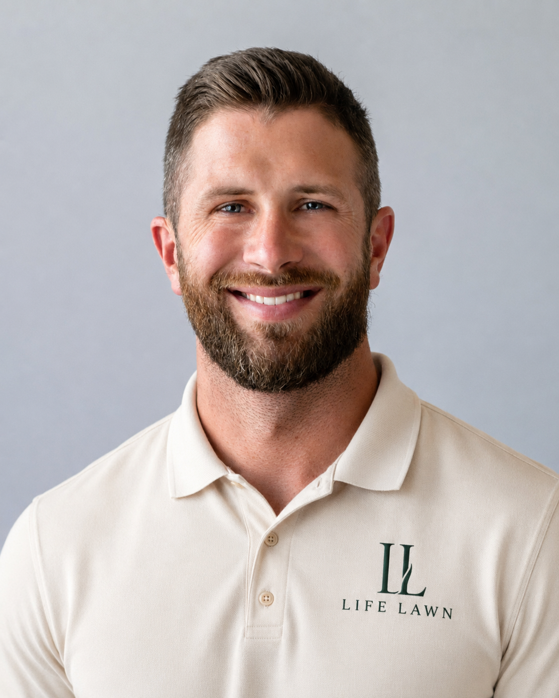 Portrait of a smiling man with a beard wearing a beige polo shirt with a "Life Lawn" logo.