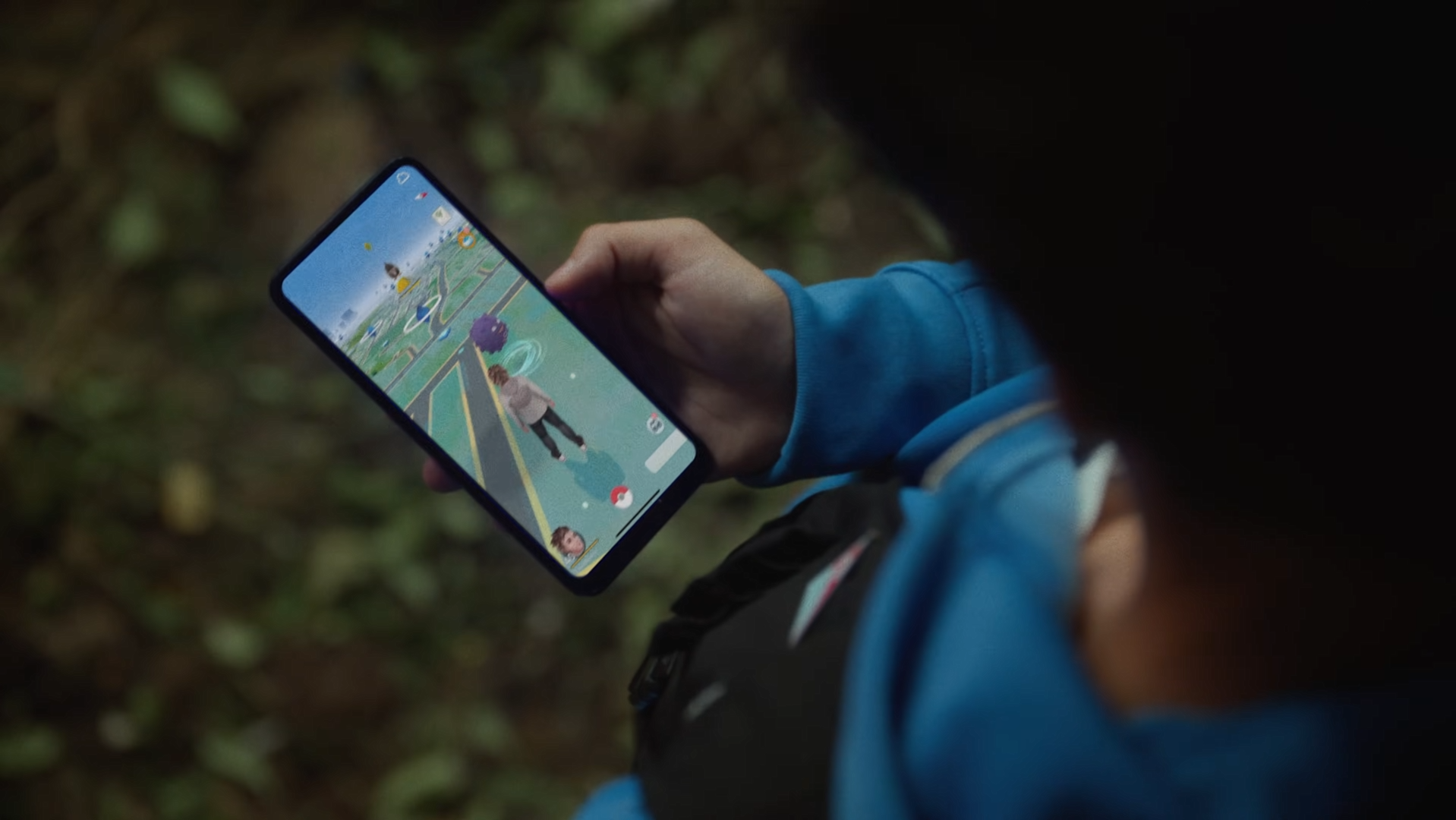 A trainer is playing Pokemon GO outdoors