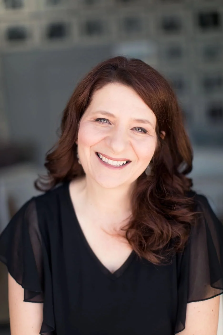 smiling woman with brown hair and a dark top