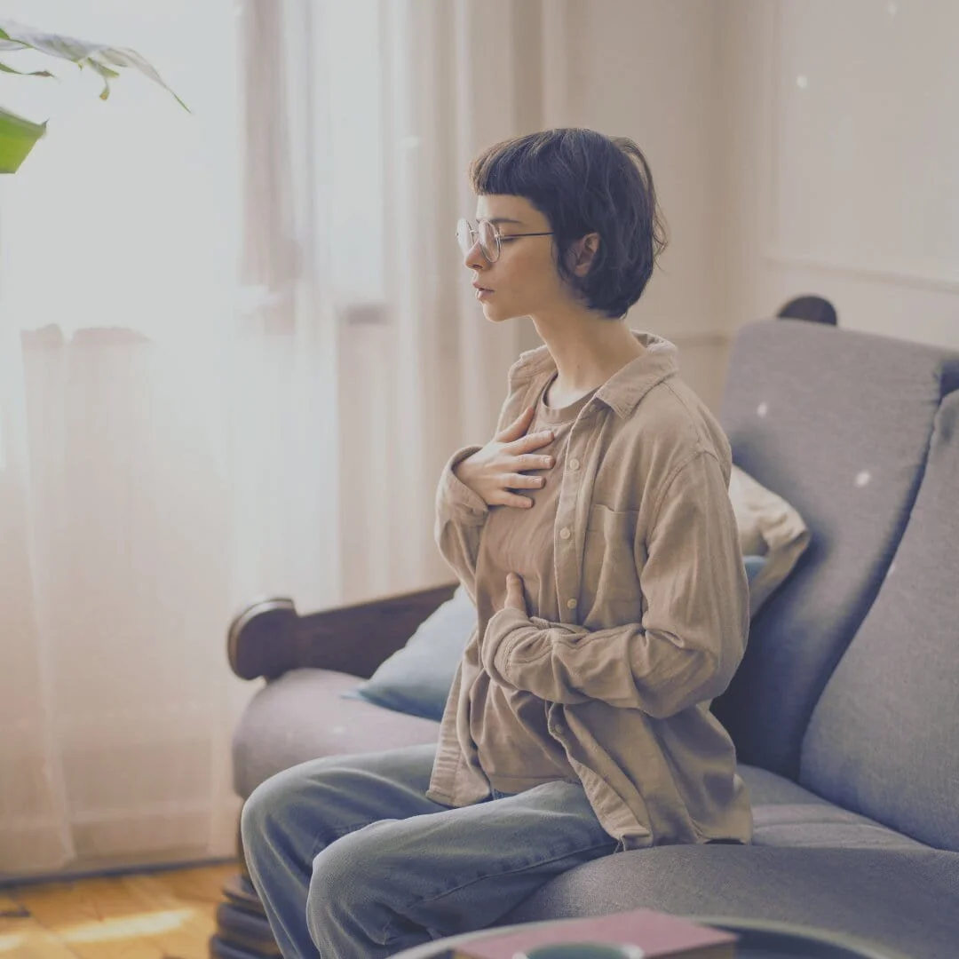woman with one hand on belly and one on chest