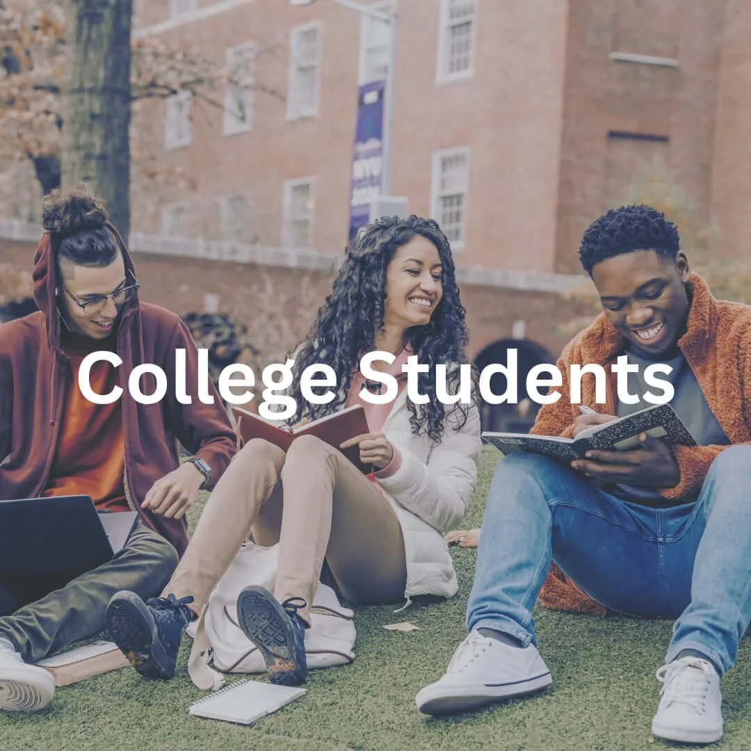 group of college students sitting together in grass