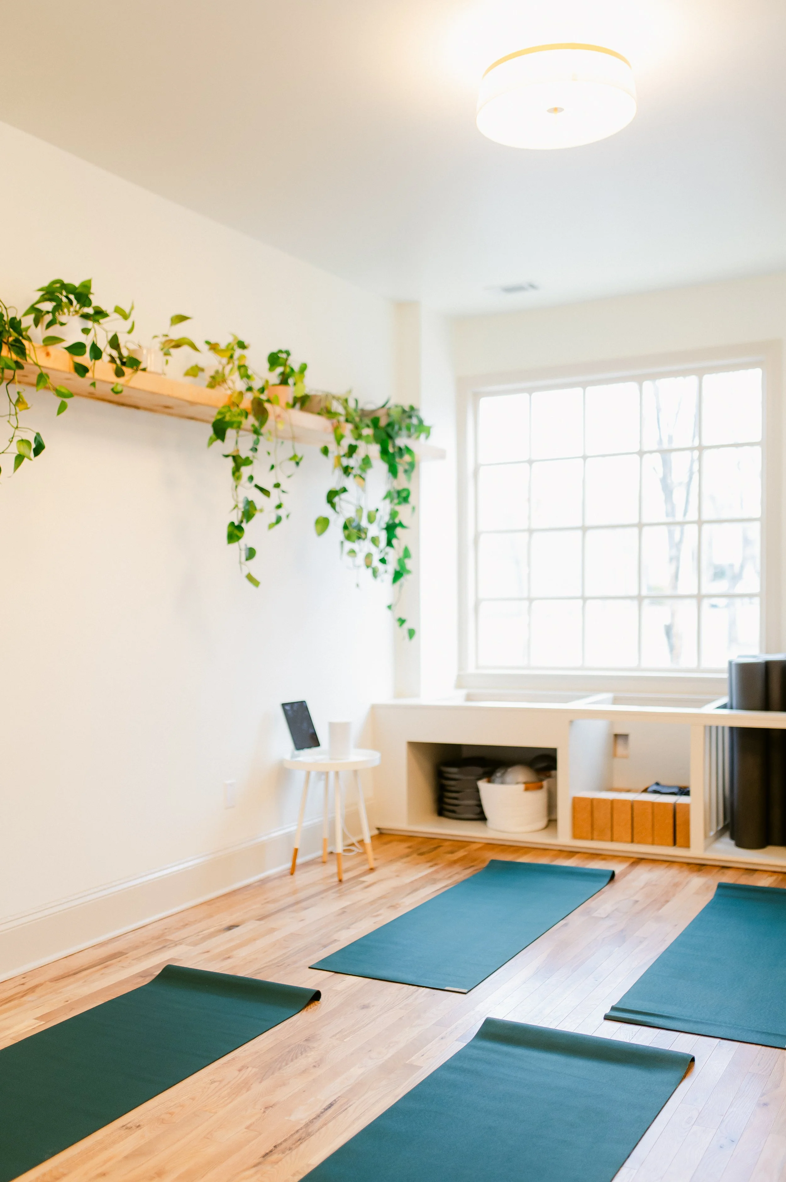Rows of mats laid on a wooden floor in the Mat Pilates studio.
