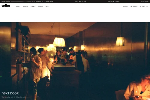 Website: Next Door, the bar beside the shop, lit by lamps at night