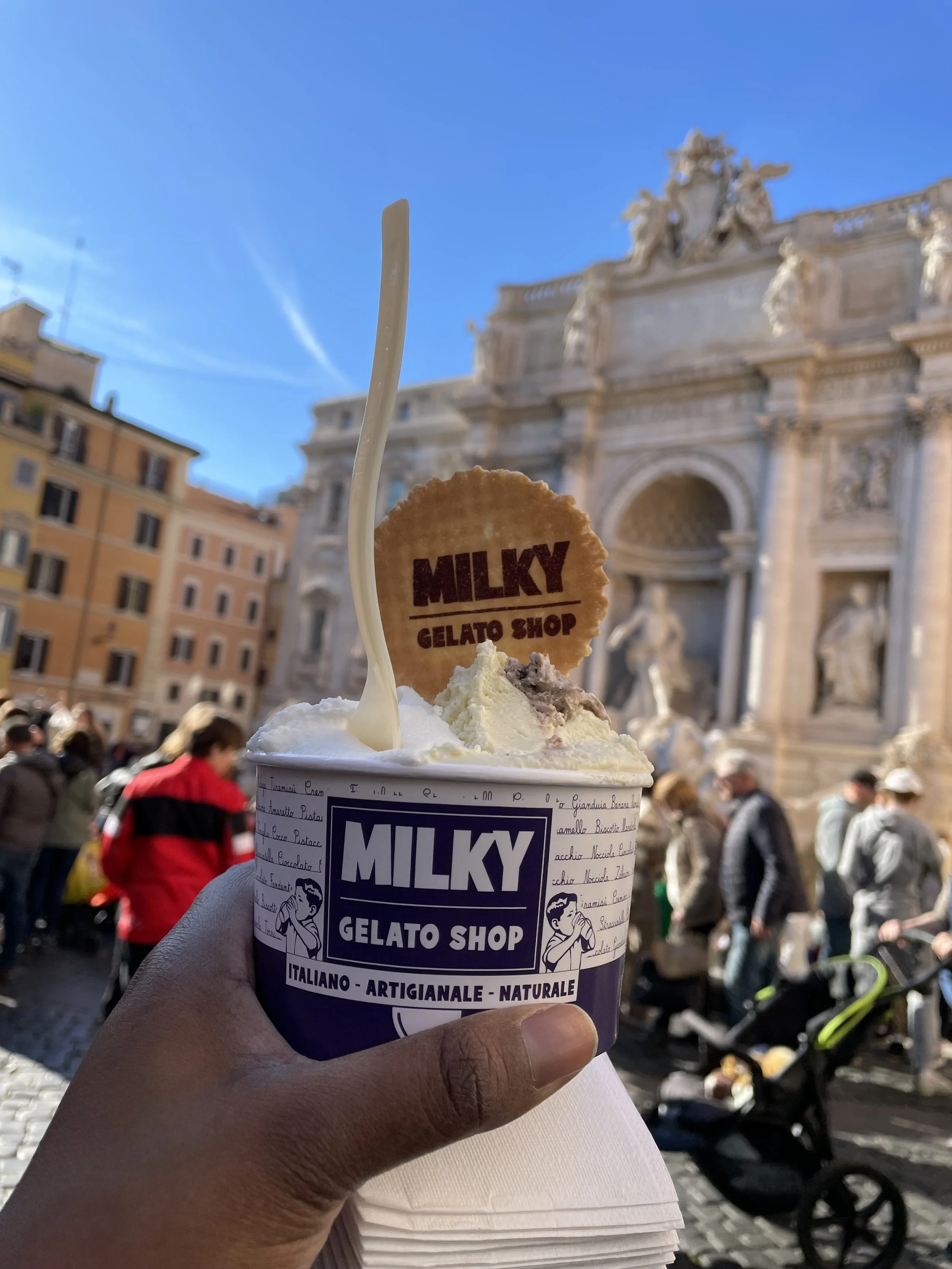 milky gelato in front of the trevi fountian rome italy
