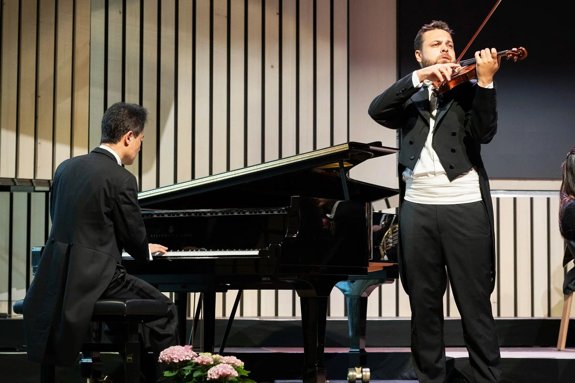 Künstler auf der Bühne im Konzertsaals des Lech Classic Festivals - ein Violinspieler im Frack sowie ein Künstler am Konzertflügel ebenfalls im Frack.