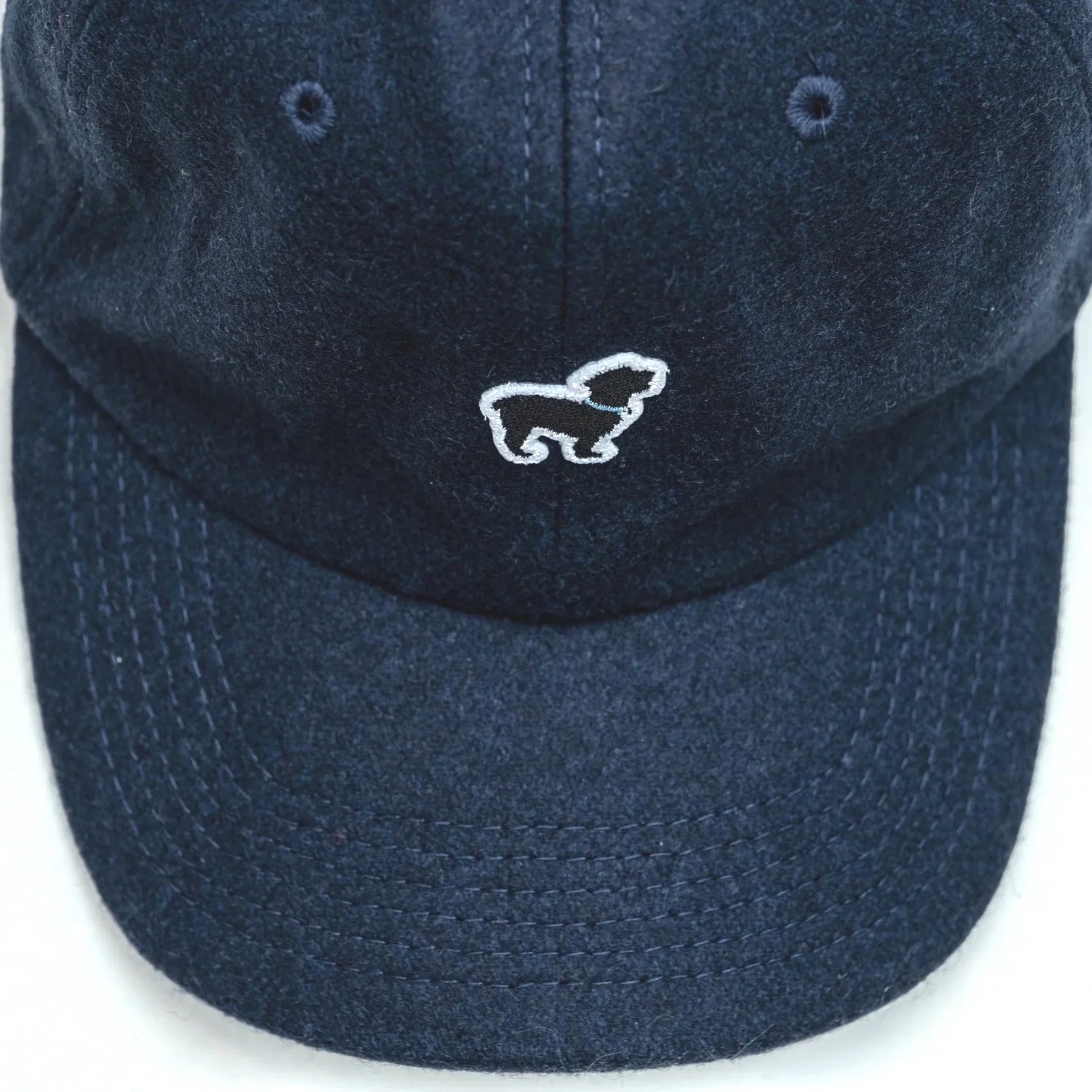 Close-up of The Official Dog of Saugatuck® logo embroidery on Navy wool cap