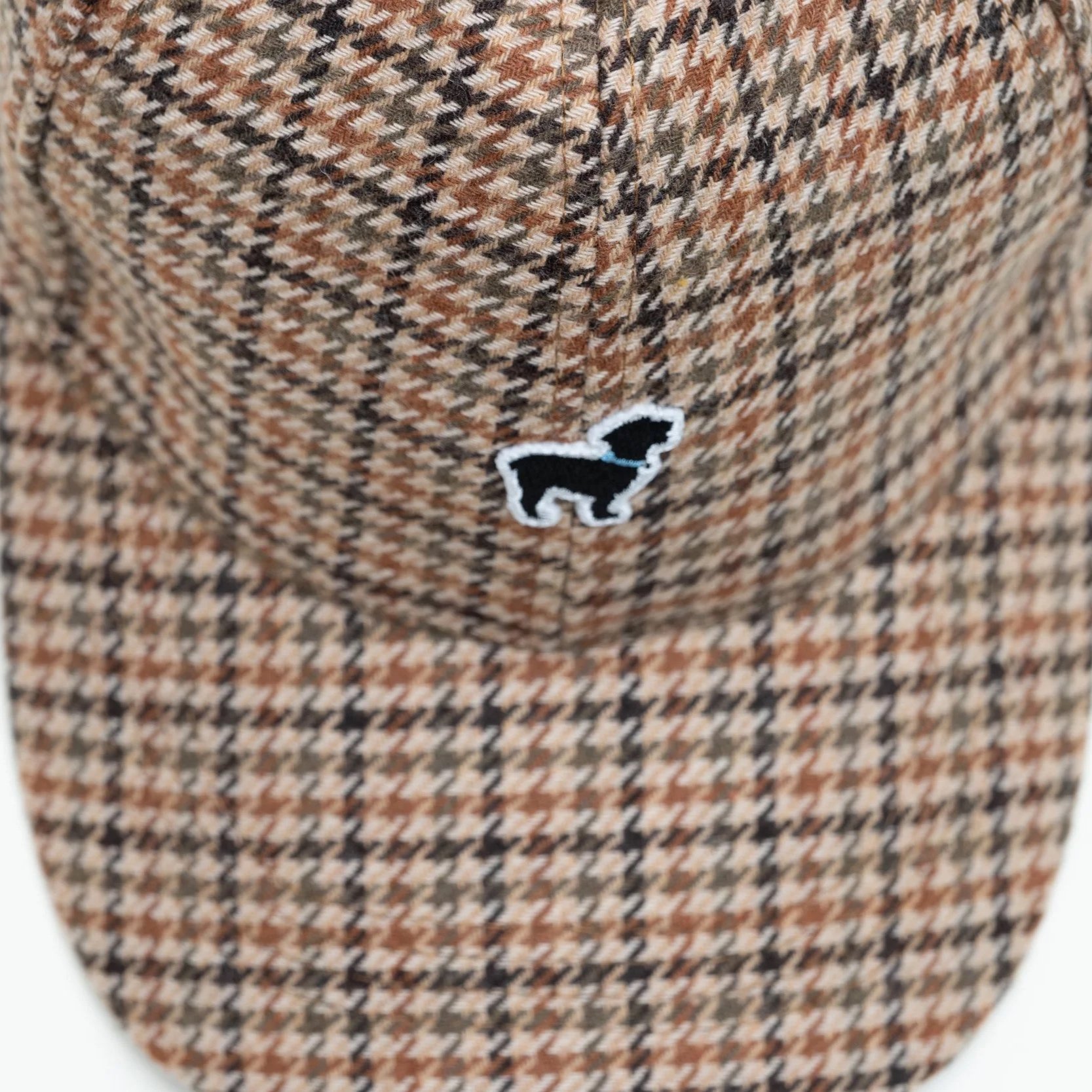 Close-up of houndstooth fabric texture on cap - Close-up of The Official Dog of Saugatuck® logo embroidery on hat