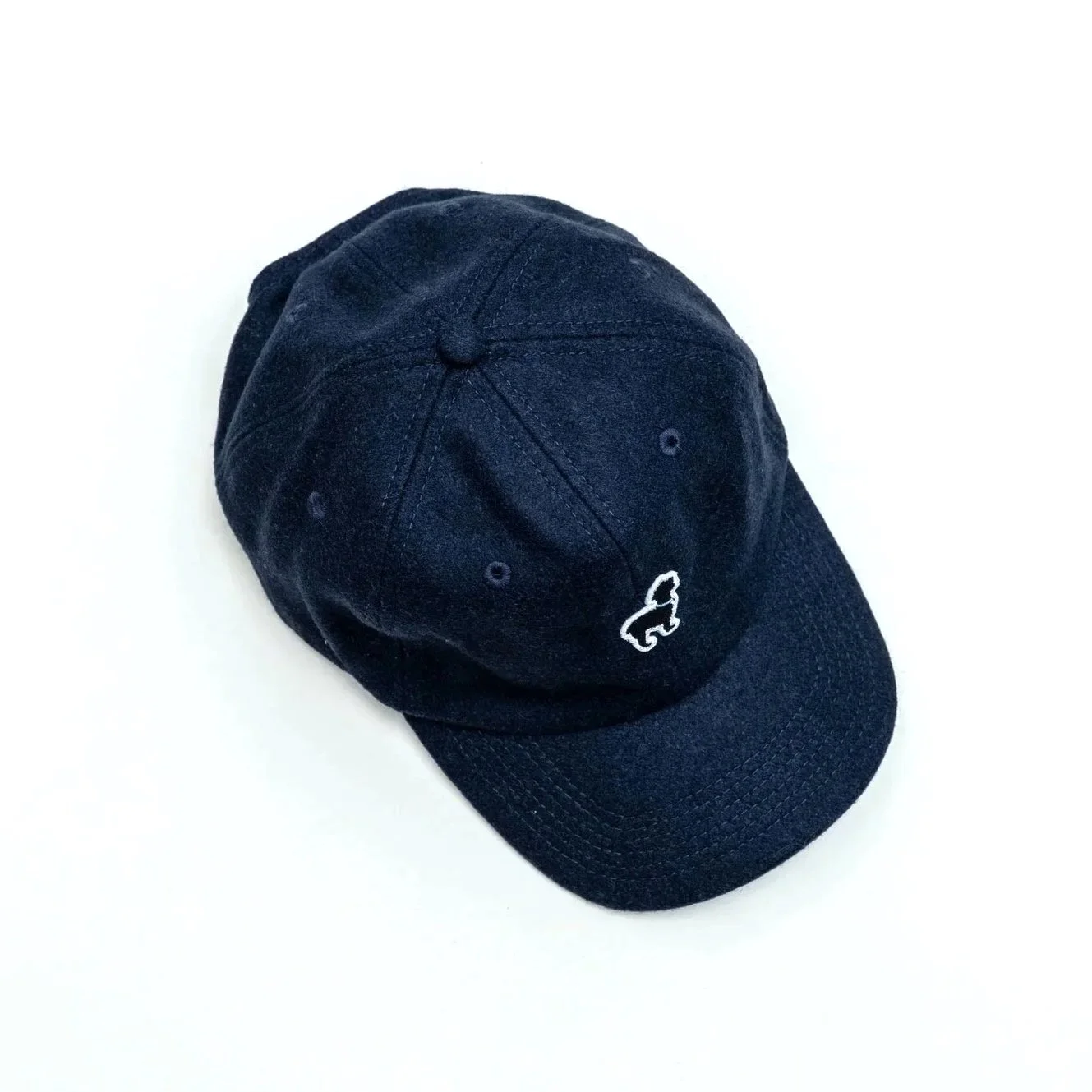 Angled view of vintage wool cap with embroidered patch logo