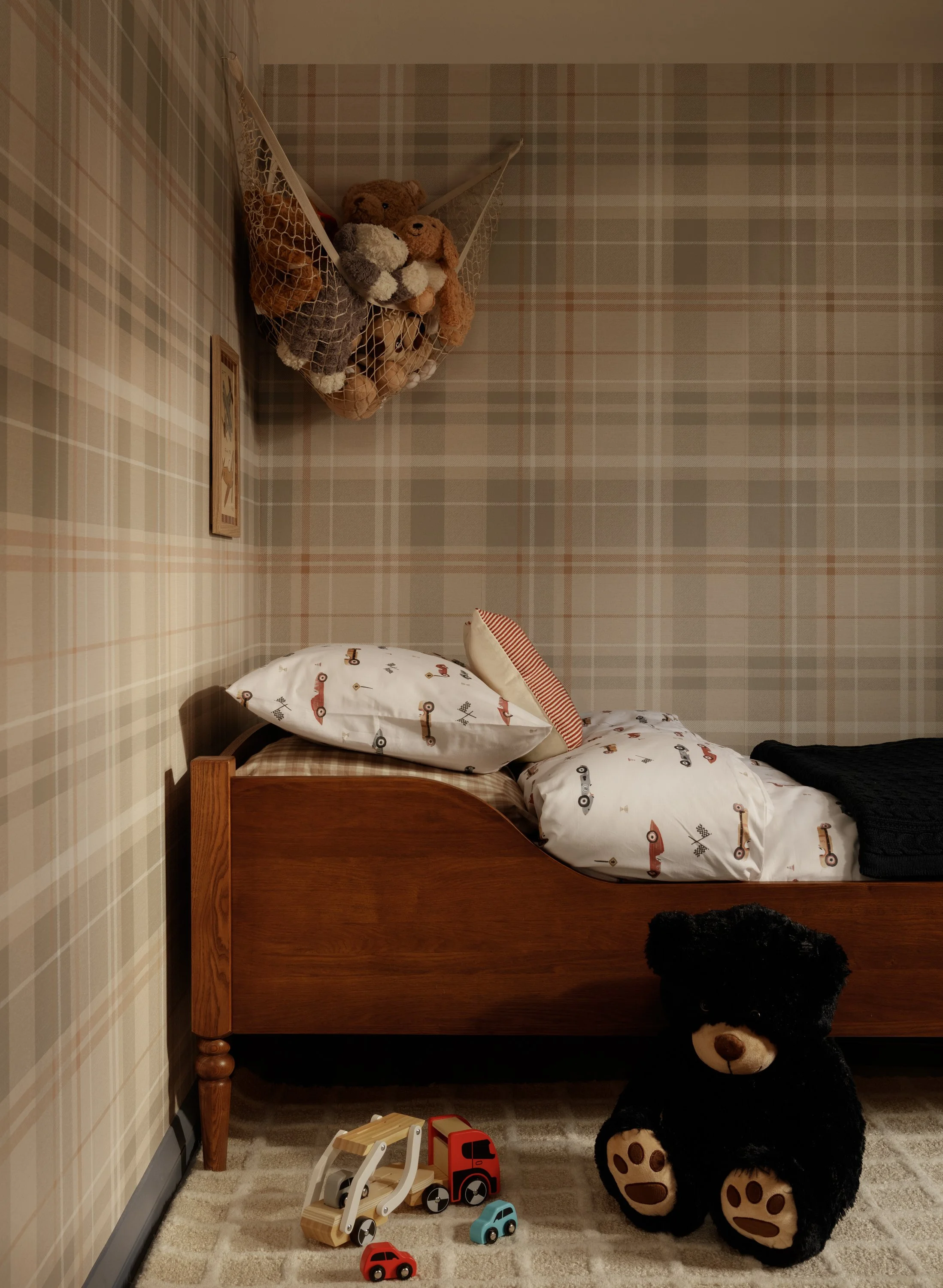 Layered children’s bedroom with plaid walls, walnut furniture and navy accents in Buckinghamshire home.