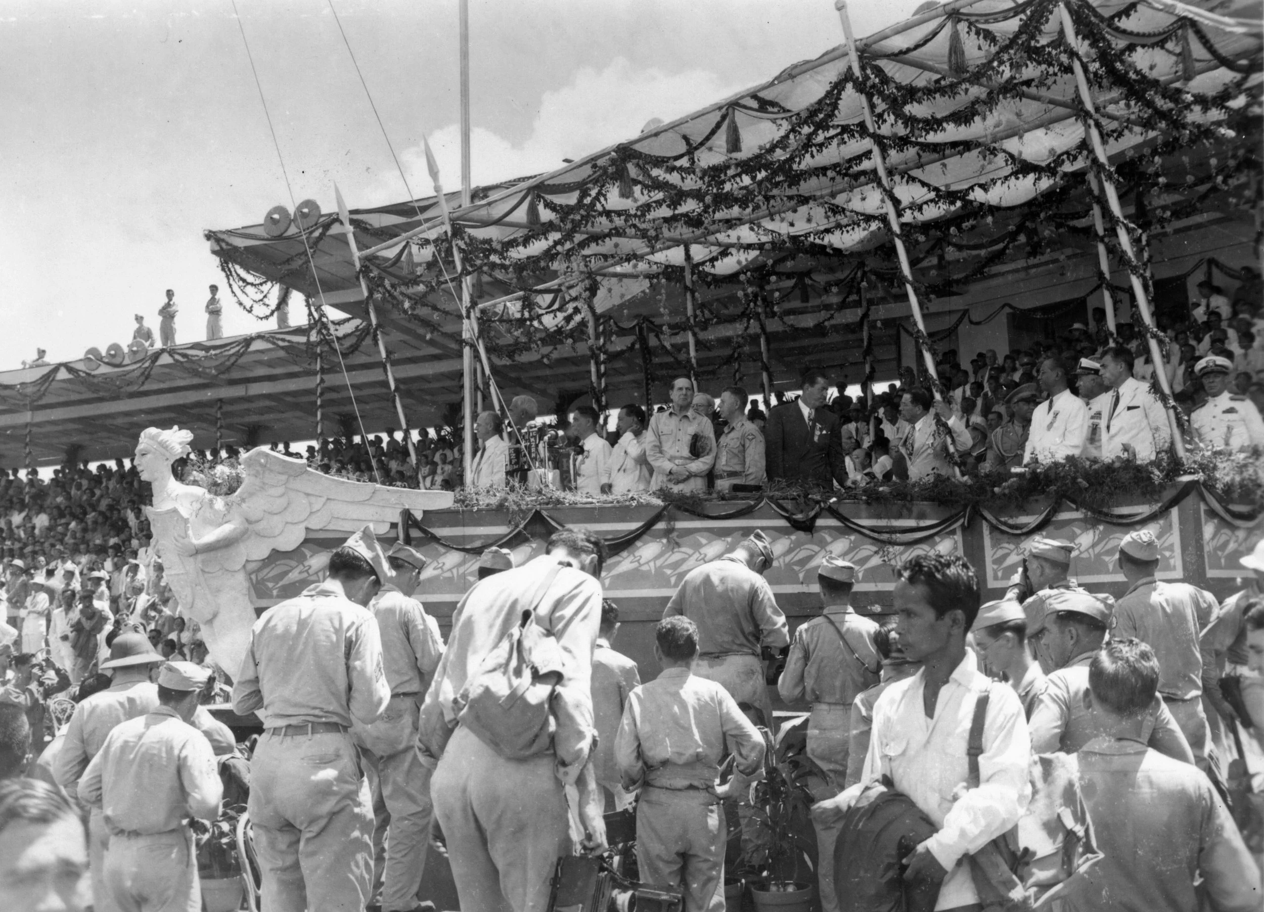 Closeup showing dignitaries on the stage.&nbsp; The stage's shape of a ship's prow (in beige and gold) with figurehead representing the newly launched Ship of State can clearly be seen in this photo (Jose 2021; Middleton &amp; Brown 1980; Duldulado 