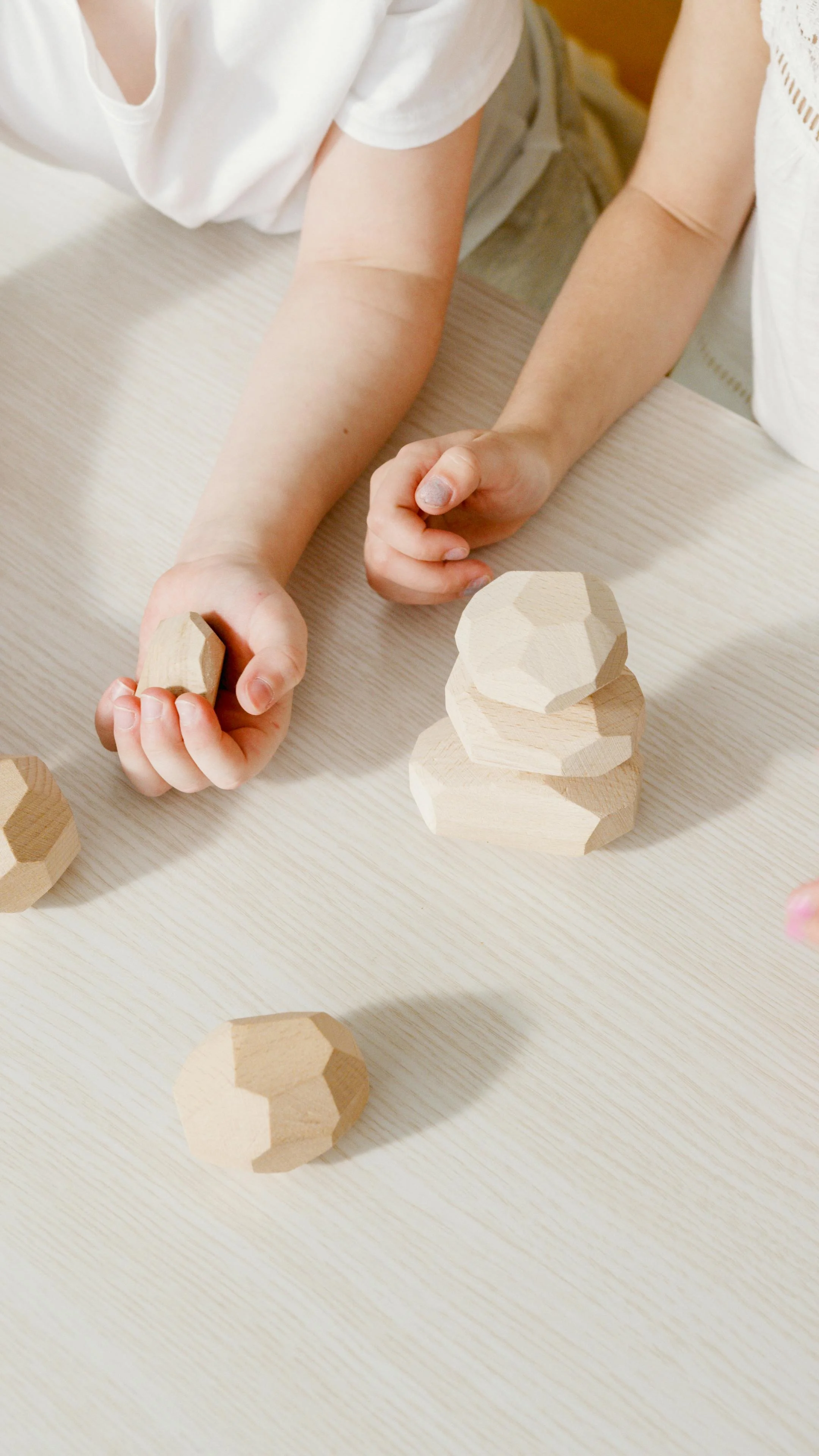 Kids are playing together with wooden stones