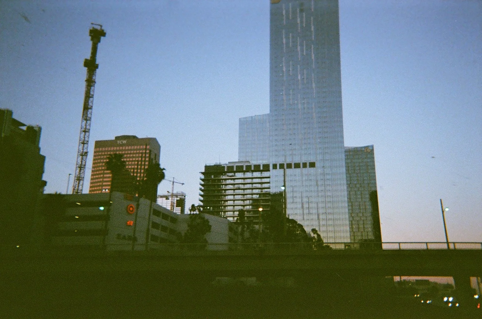 City skyscrapers and construction cranes at dusk.
