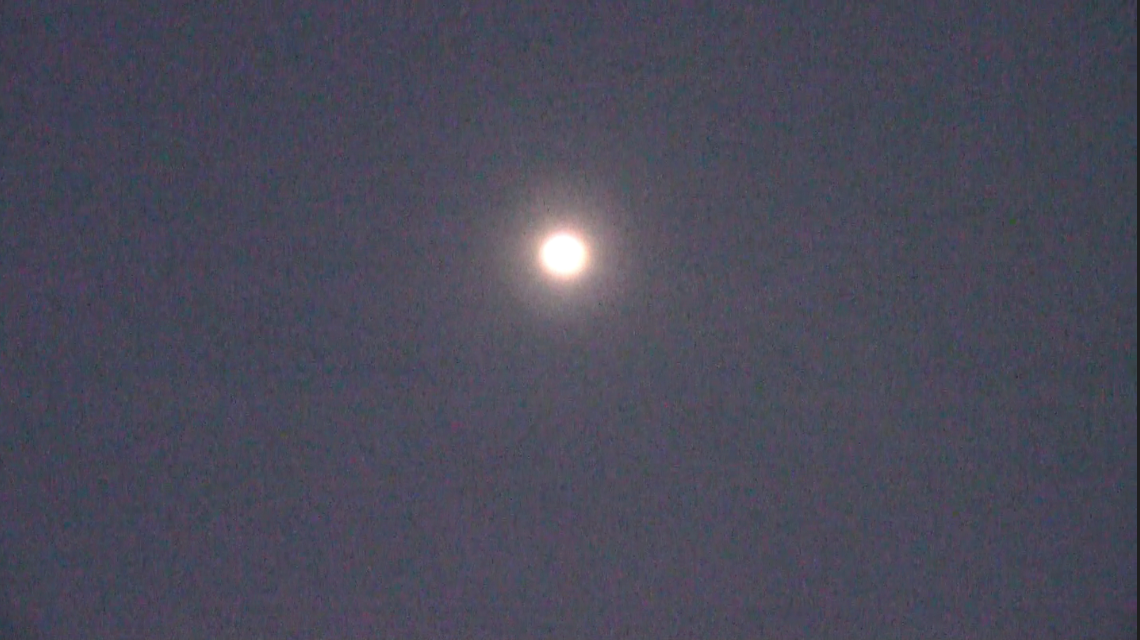 A bright full moon in a dark night sky.