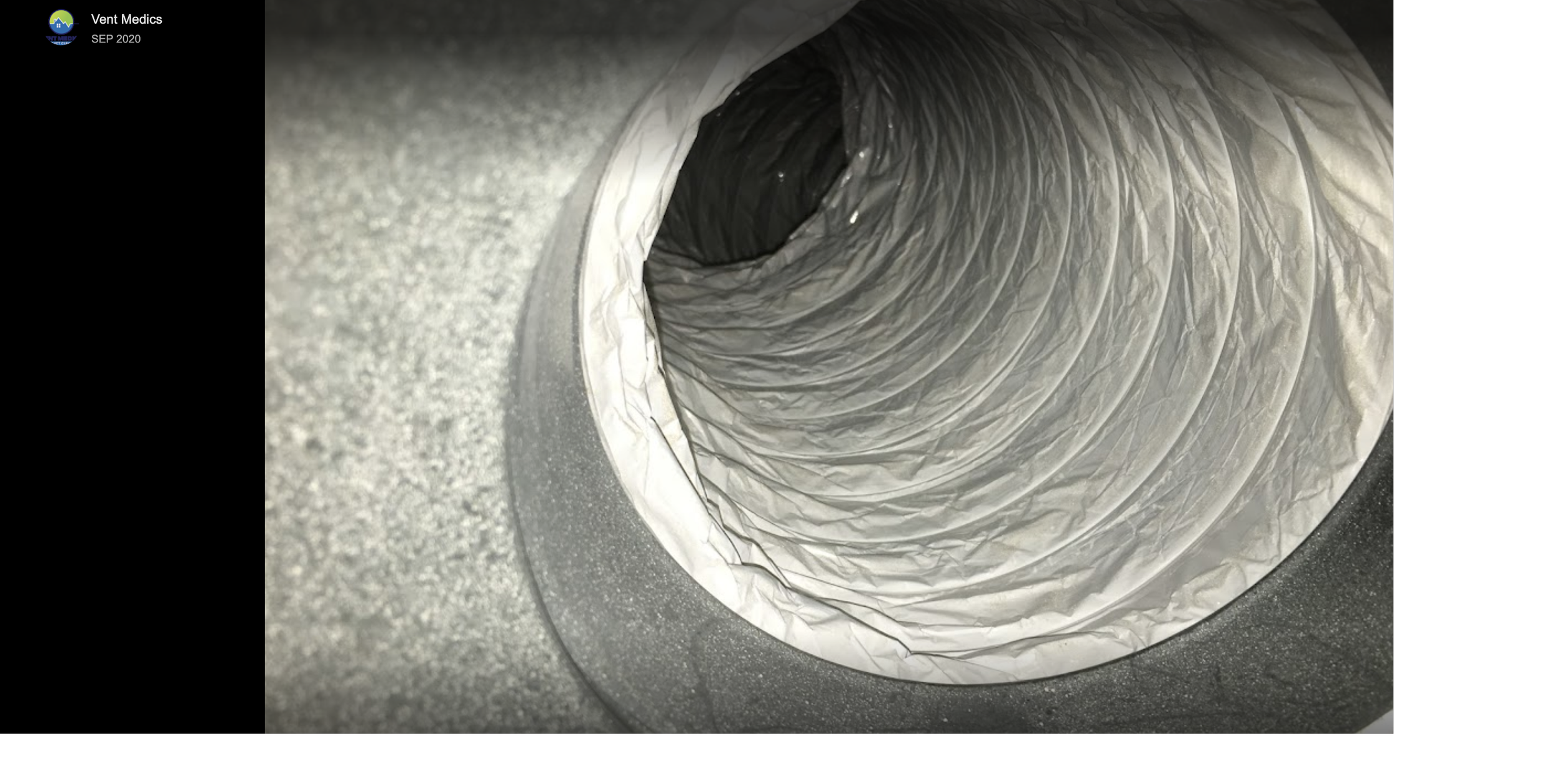 Close-up view of a circular galvanized metal duct with insulation material inside.