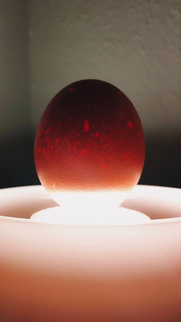 A creative photo of an egg on top of a lamp
