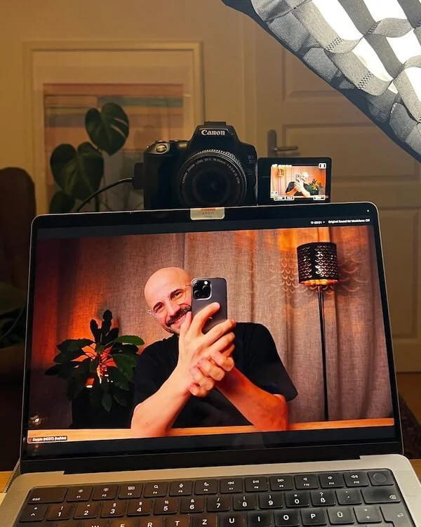 A host and instructor of a mobile photography workshop is taking a selfie while running a workshop