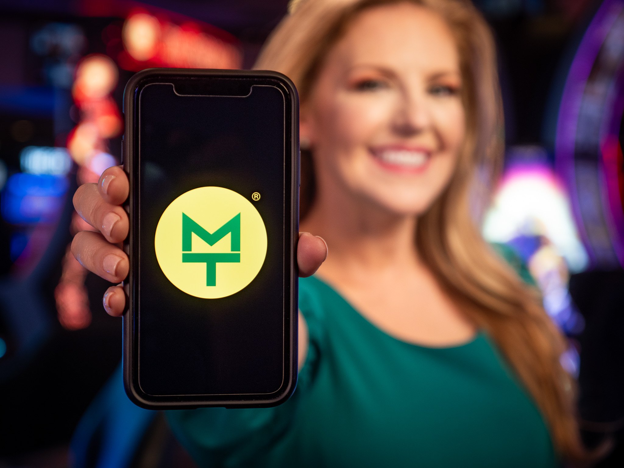 Promotional brand video production for a tech app, featuring a vibrant display on a smartphone held by a smiling professional in Las Vegas – highlighting local business and brand video services.