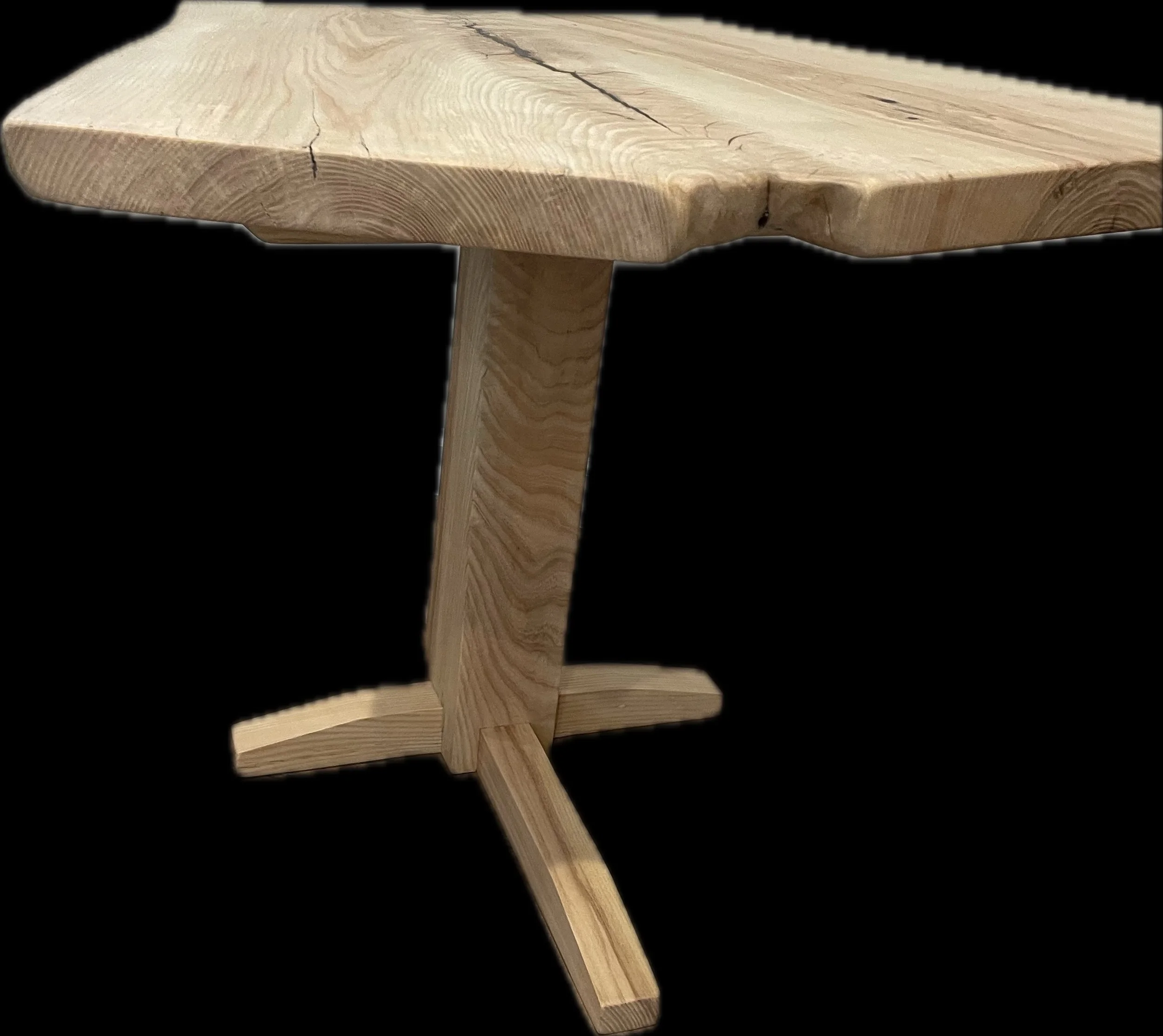 A light toned wooden side table made with a black background made to highlight the woods beauty. 