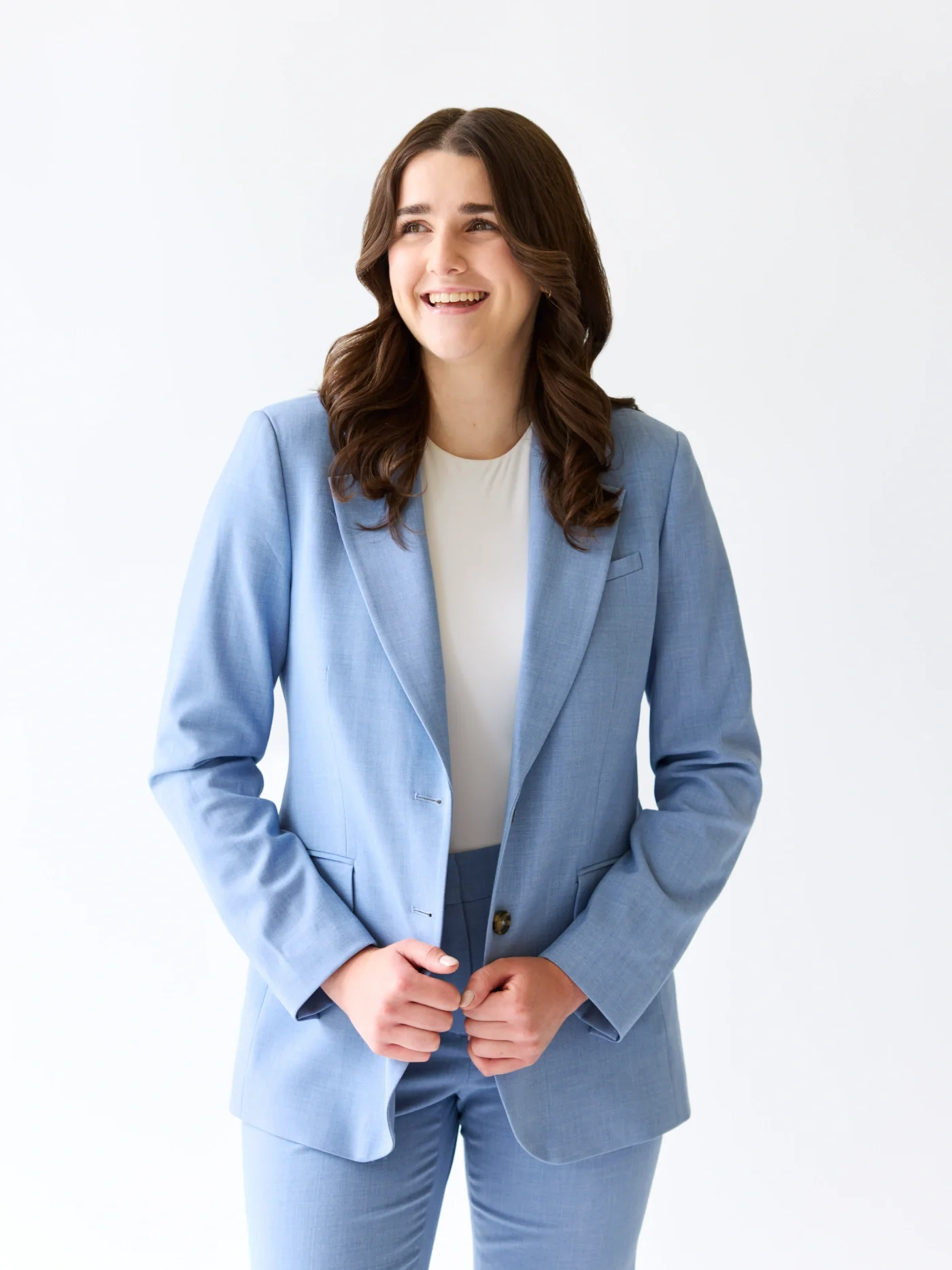 Taylor of With Ease Therapy Space in Guelph wearing a light blue suit, looking off to the side, and smiling at the camera.