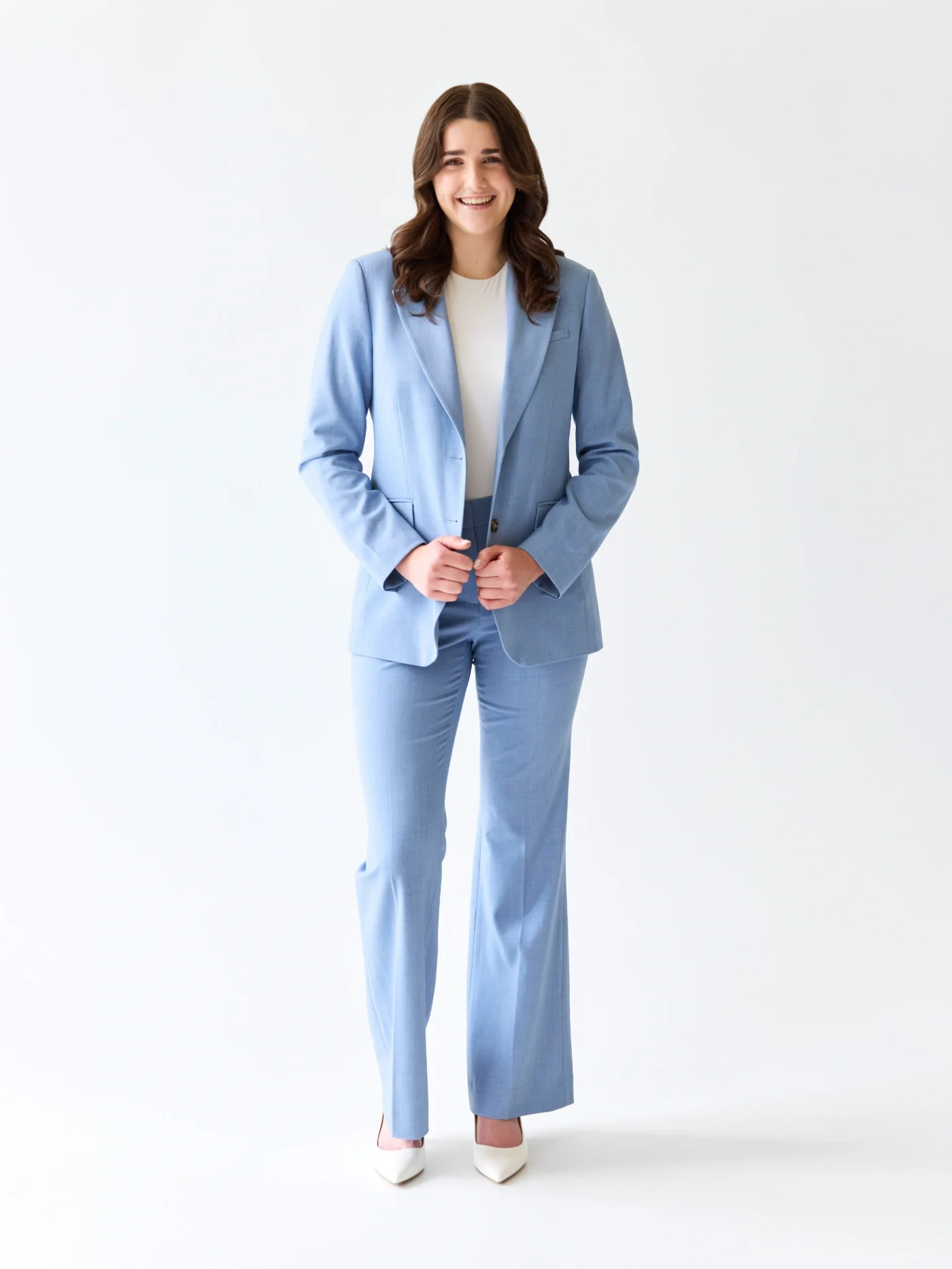 Taylor of With Ease Therapy Space in Guelph wearing a blue suit, standing in front of a white backdrop and smiling at the camera.