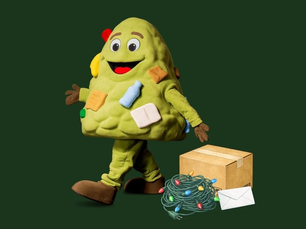 Land Phil walking past a pile of holiday lights, a cardboard box, and an envelope