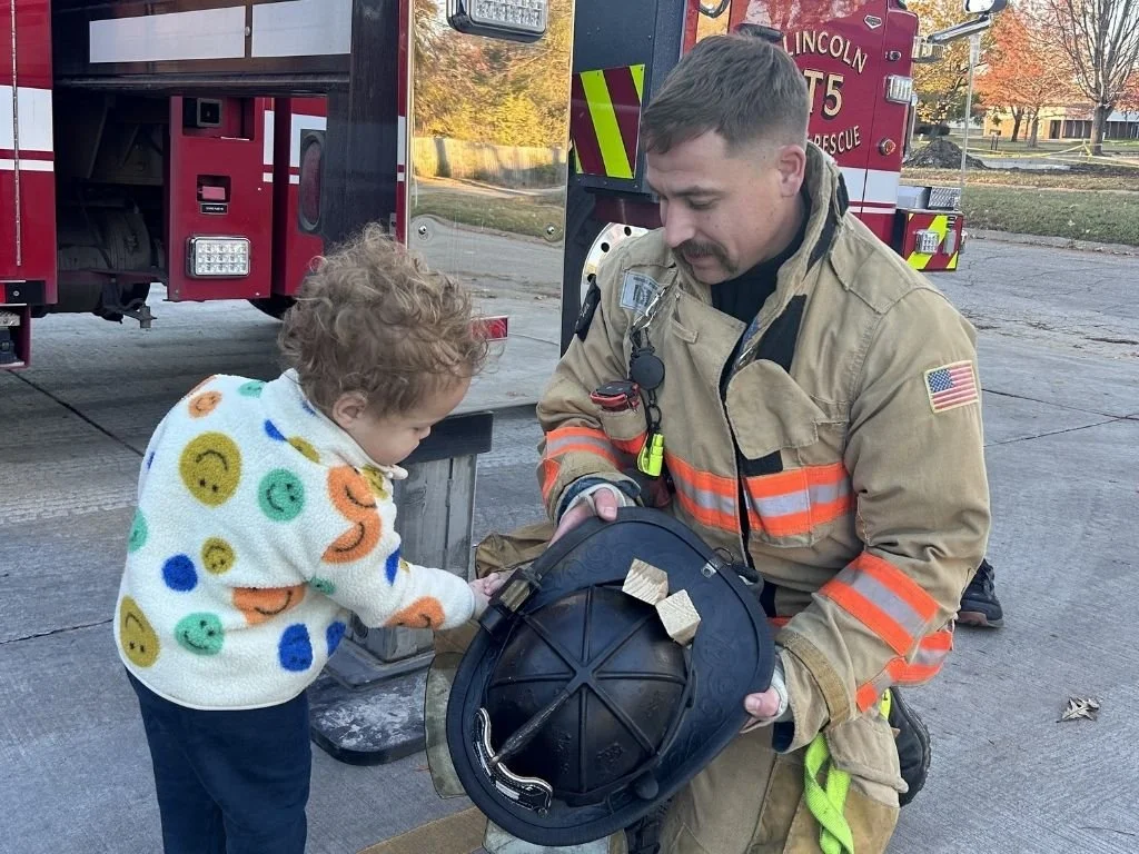 Young firefighter in uniform talking to young boy