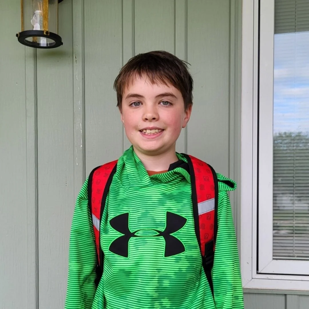Young boy smiling with backpack