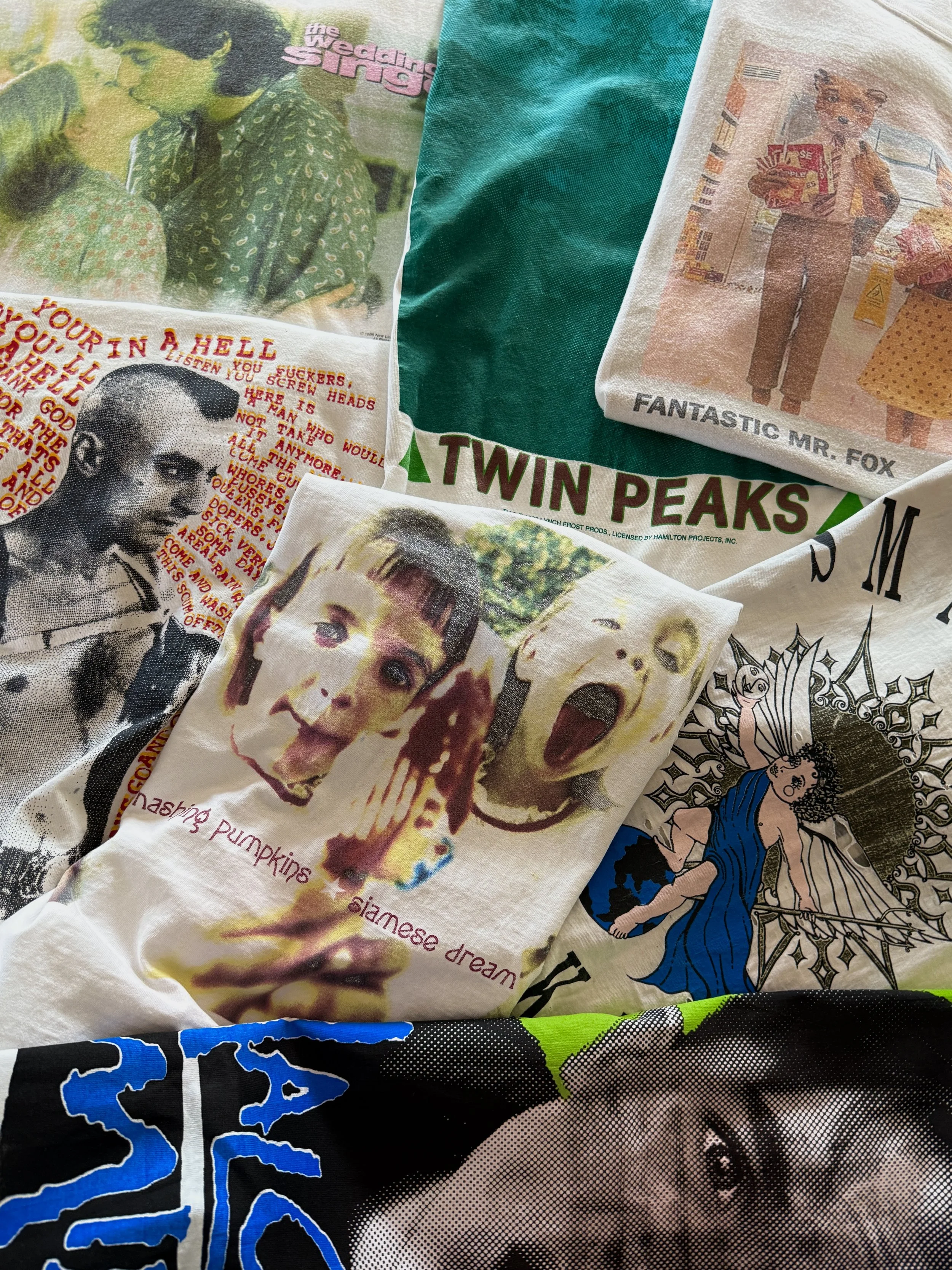 A collection of printed fabrics featuring various images and text, including portraits, movie references, band logos, and artistic designs.