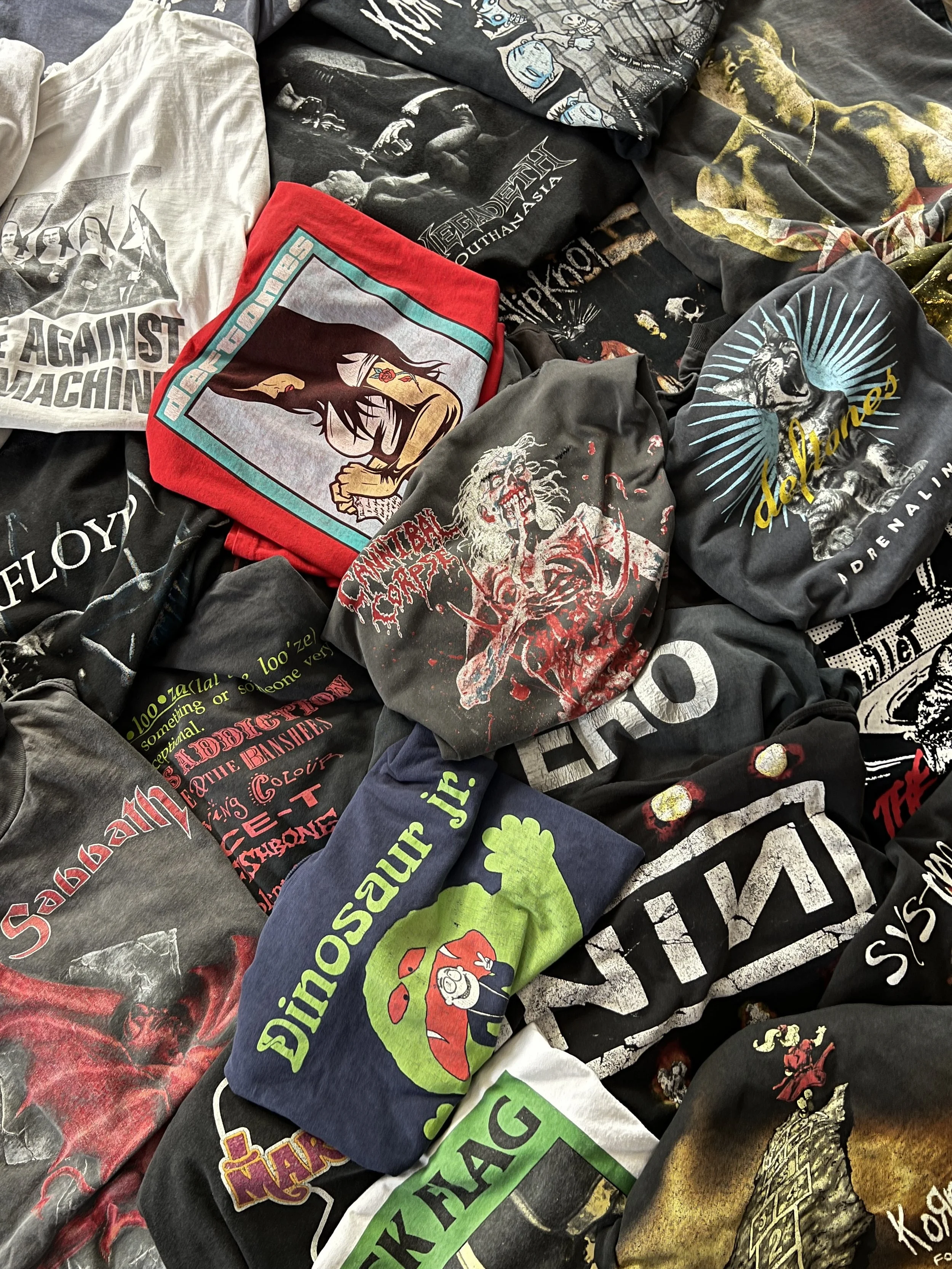 Collection of band t-shirts featuring logos and album art from various rock and metal bands, including Iron Maiden, Metallica, and Pink Floyd.