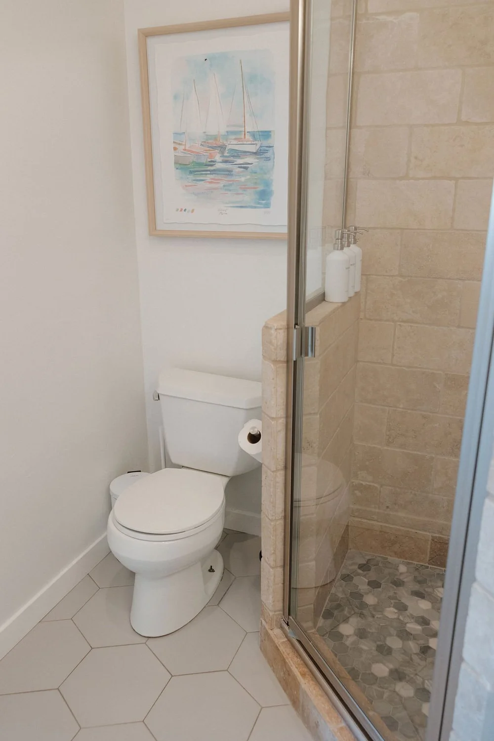 A bathroom in The East Cove with a glass shower and a navy vanity