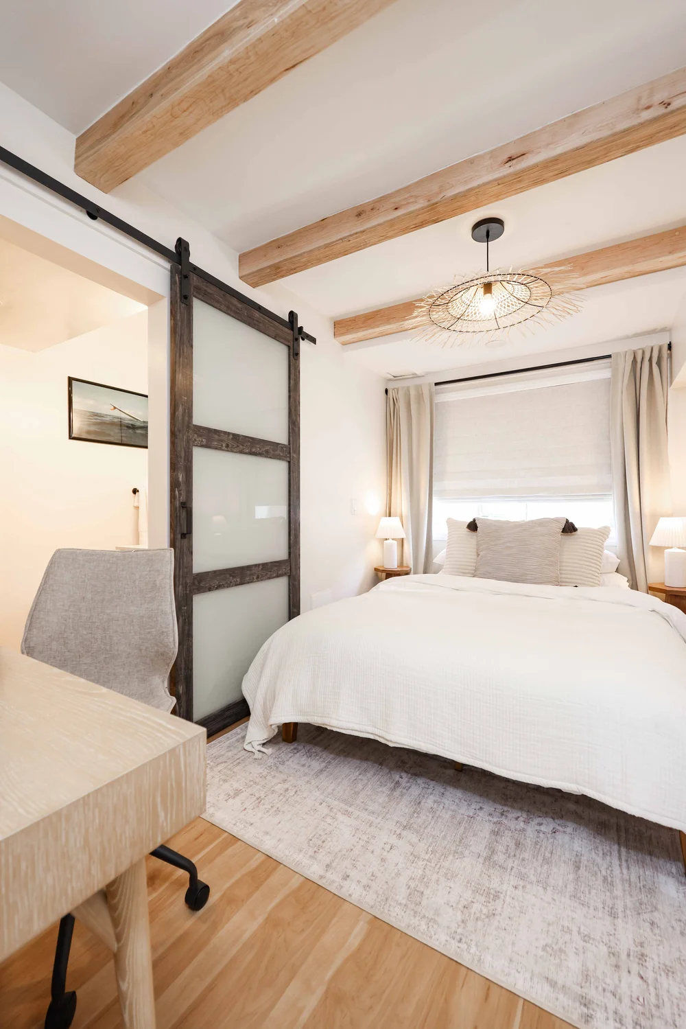 The bedroom through the sliding barn door in Unit Two at The Swell, Oceanside