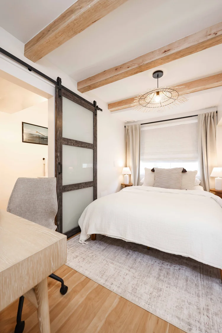The bedroom through the sliding barn door in Unit Two at The Swell, Oceanside