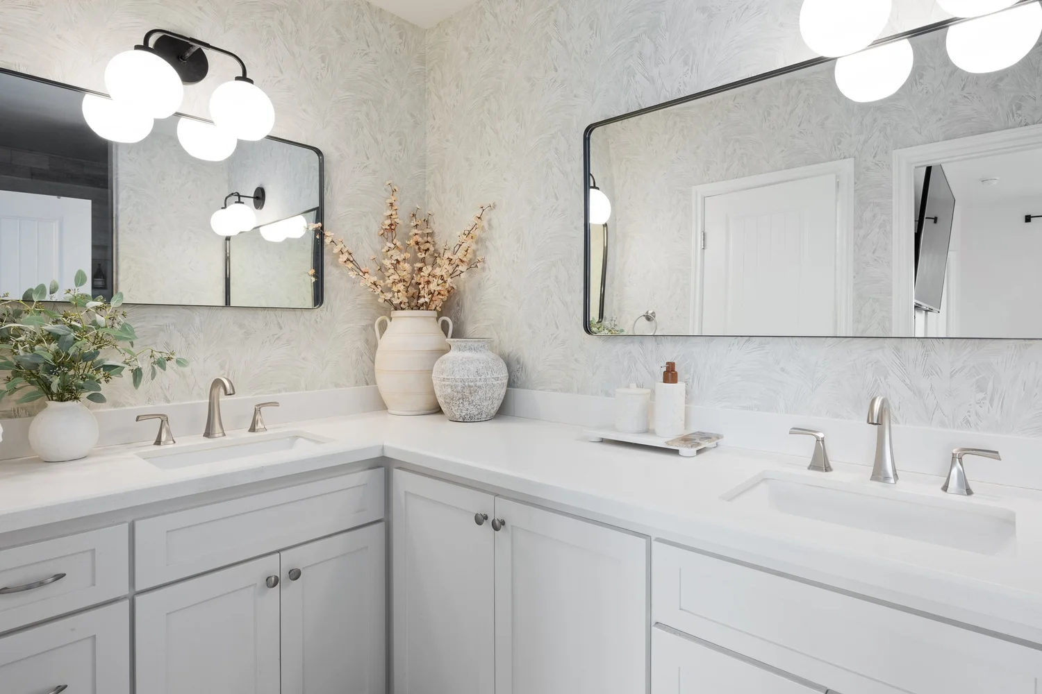 Bathroom with a double vanity, gray cabinets and globe lights at Coastal Palm in Pacific Beach, designed by Salt and Sky Lodging Co.