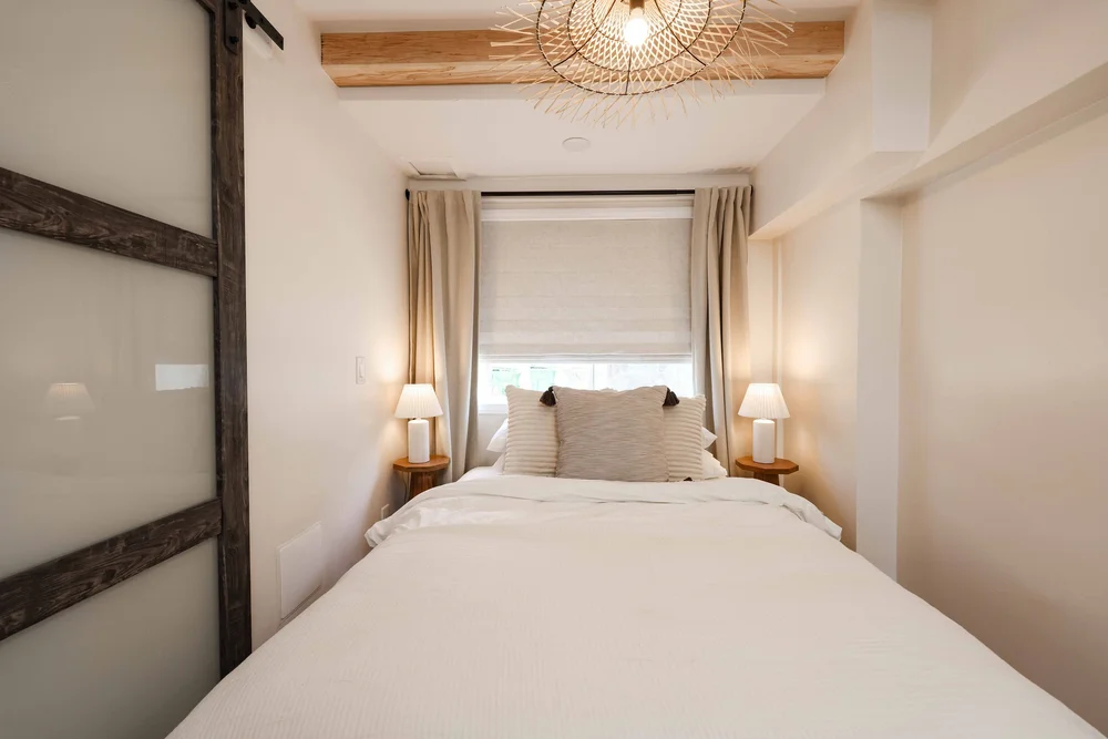 The queen bedroom with a woven pendant in Unit Two at The Swell, Oceanside
