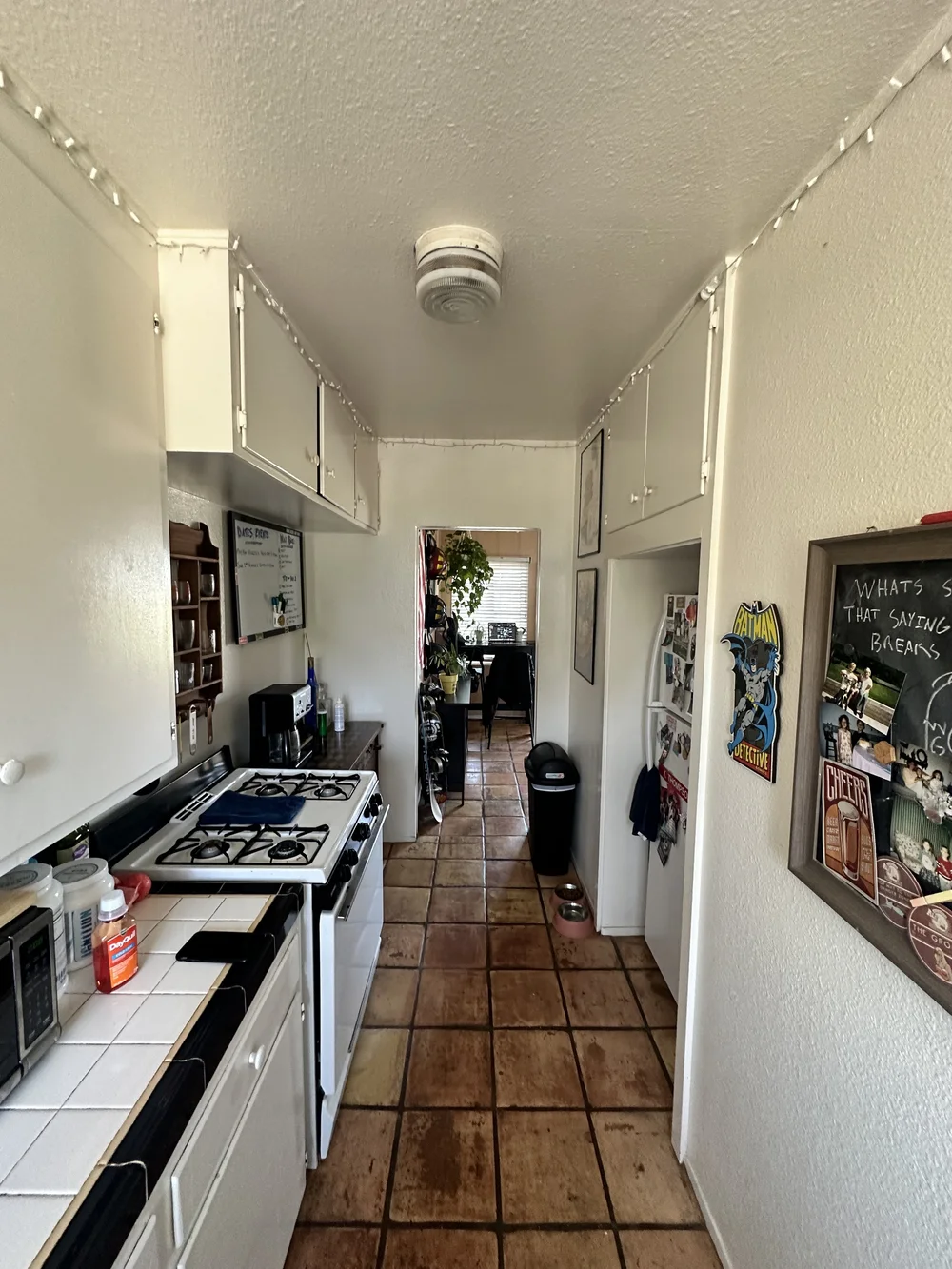 Before: Galley kitchen with a tile floor at Clementine C in Oceanside