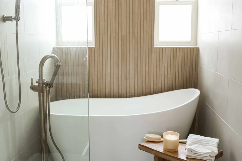 The spa bathroom in Unit One at The Swell, with a freestanding soaking tub against a wood slat wall