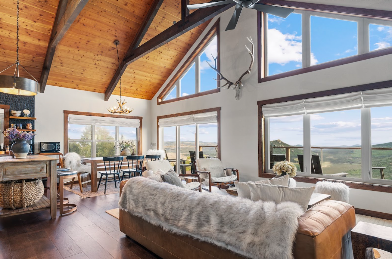 Vaulted wood-beam living room at Wild Moon Ranch with floor-to-ceiling windows overlooking the mountains near Julian, CA
