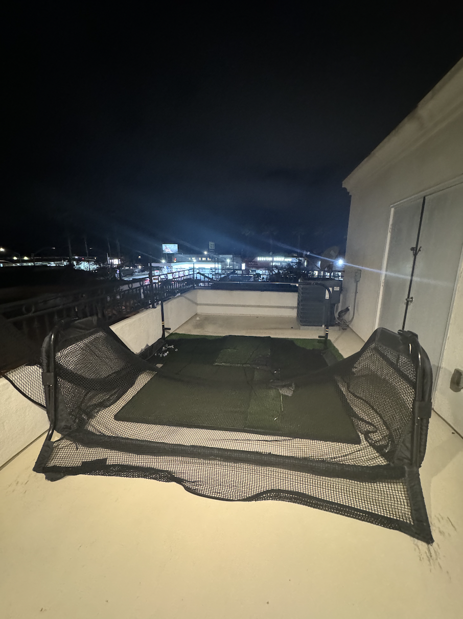 Before: Roof deck at night with a golf net at Coastal Palm in Pacific Beach