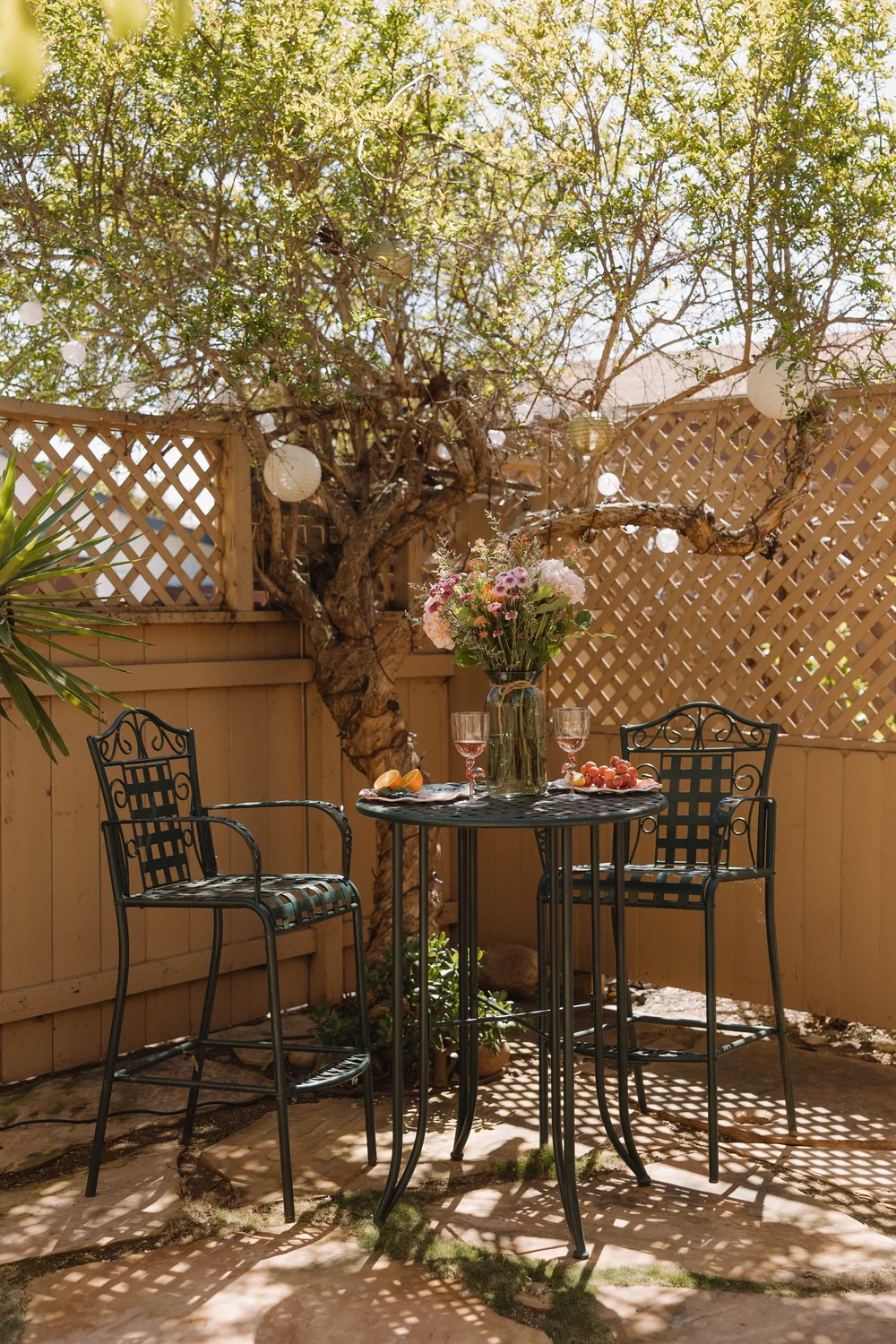 A bistro table and chairs on a side patio with lattice at Palm Parkside