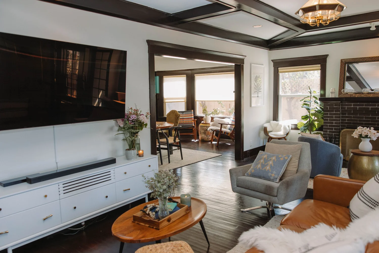 The living room at Palm Parkside near Balboa Park with coffered ceilings, original dark wood trim and a wall of windows