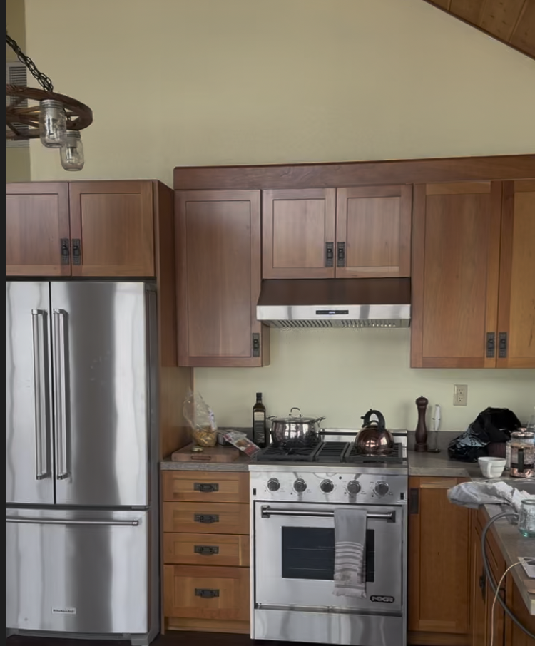 Before: kitchen with honey oak cabinets and a stainless range