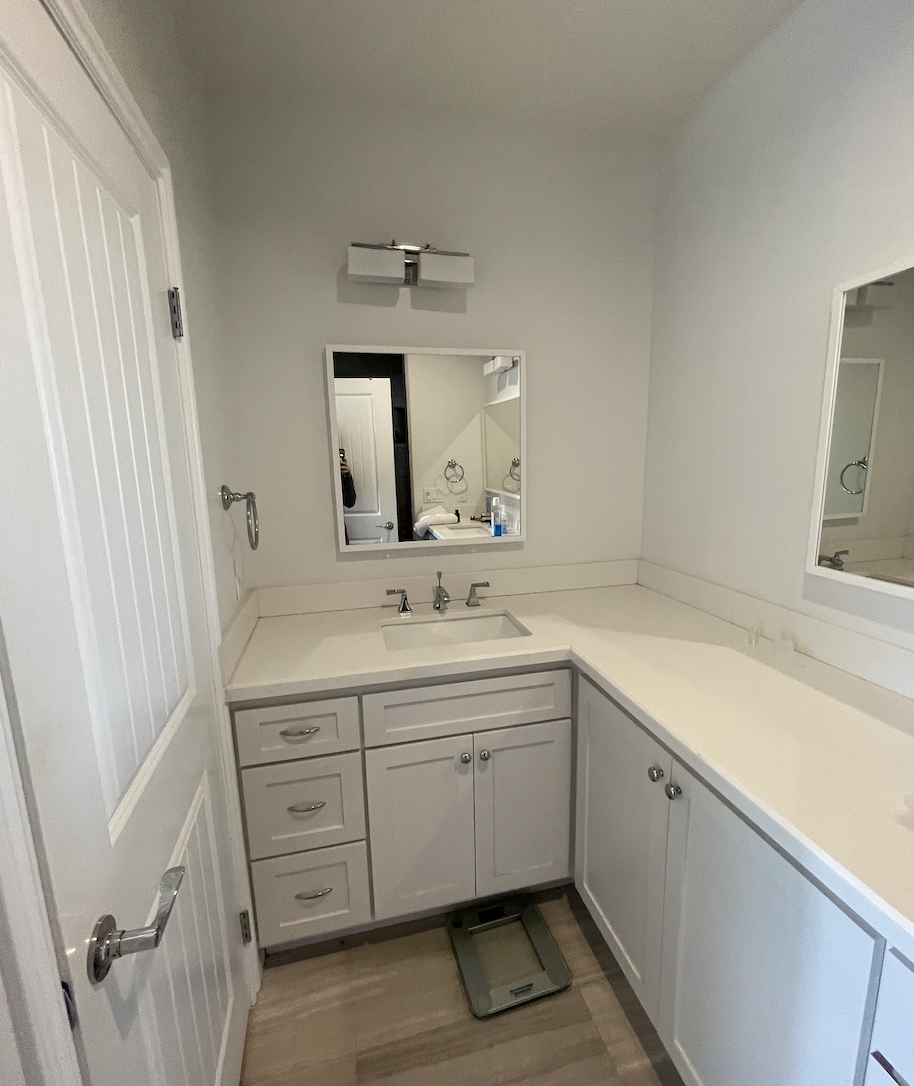 Before: Bathroom vanity with white cabinets at Coastal Palm in Pacific Beach