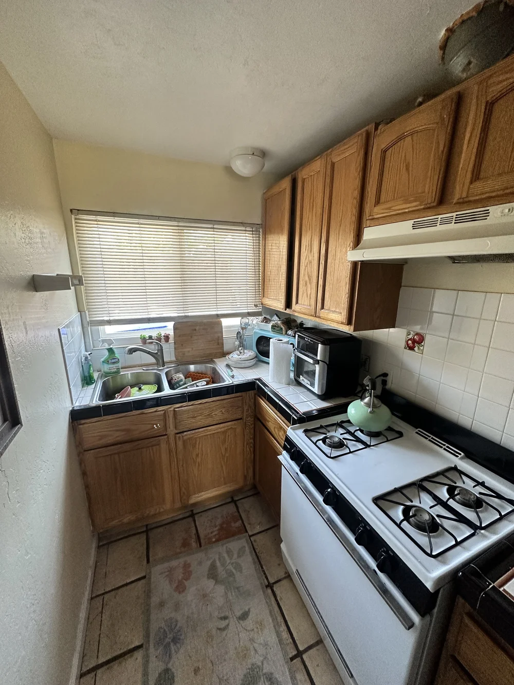 Before: Kitchen with oak cabinets and a white range at Clementine B in Oceanside