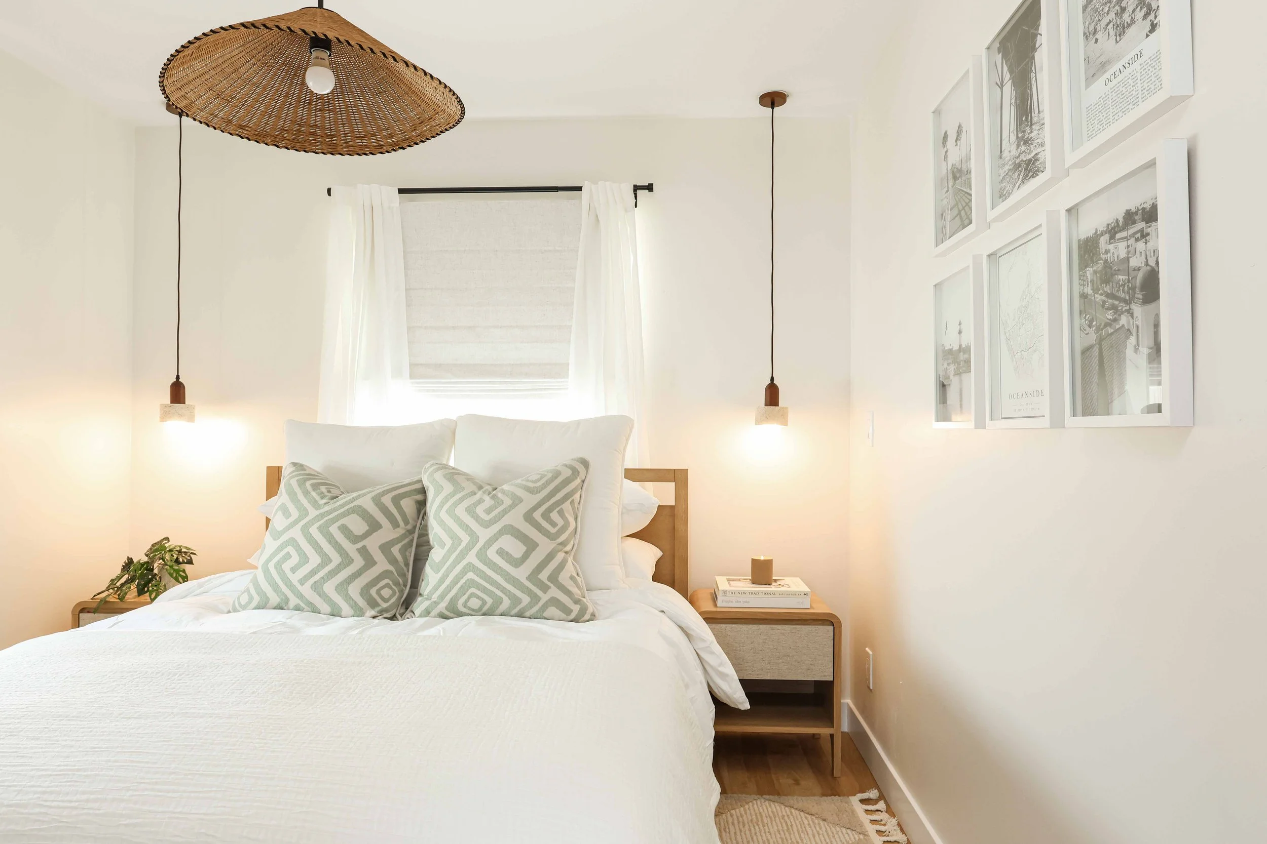 Bedroom with a woven pendant, two hanging lights and framed art at Clementine B in Oceanside, designed by Salt and Sky Lodging Co.