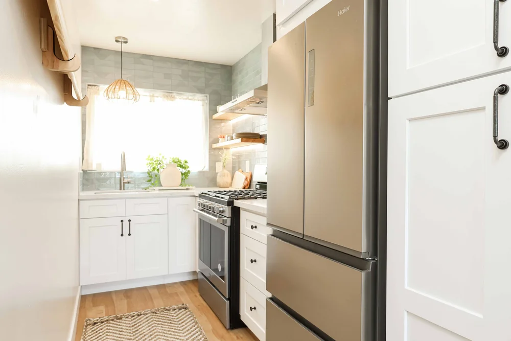 The kitchen with a stainless steel fridge and open shelves in Unit One at The Swell, Oceanside