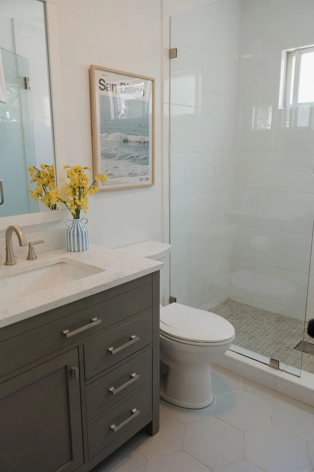 The bathroom in The Sandbar studio with a gray vanity and a glass shower