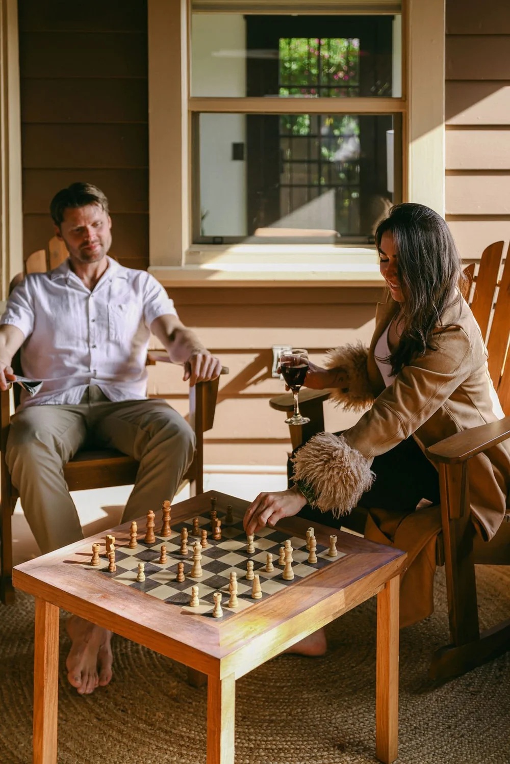 Two guests playing chess in the rocking chairs on the front porch at Palm Parkside