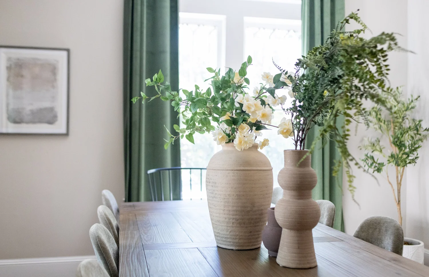 Dining table with plants and green velvet curtains at Elmsgate in Birmingham, designed by Salt and Sky Lodging Co.