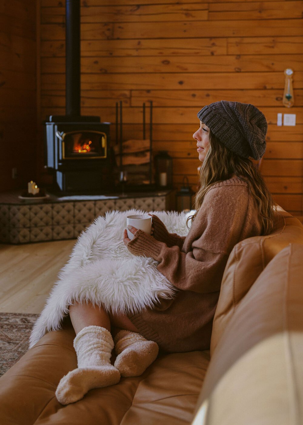 Curled up in a blanket beside the wood burning stove at Dark Moon Chalet near Julian